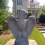 Winged creature statue in front of Real Estate near Potomac River
